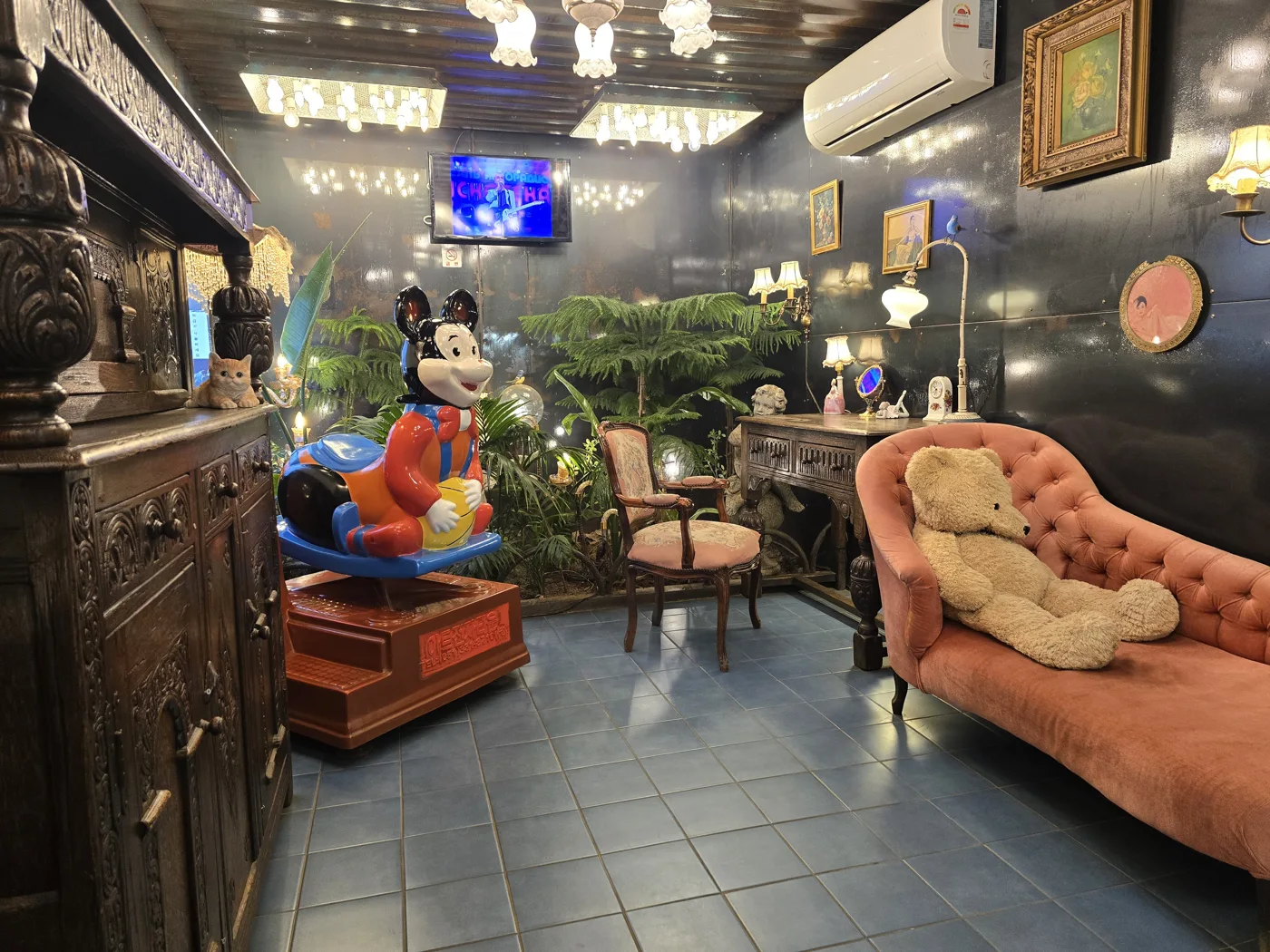 A room filled with eclectic furniture, lamps and decorative objects